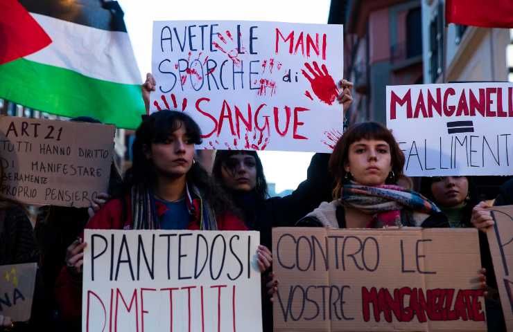 Cartelli in un corteo contro le manganellate sugli studenti.